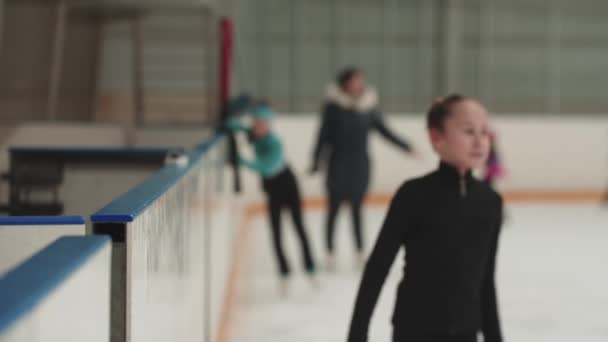Duas meninas figura patinadores reunião nos portões da pista pública e falando — Vídeo de Stock