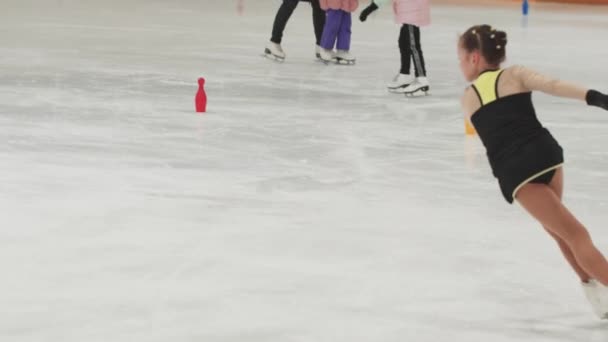 Kislány műkorcsolyázó edzés jelmez korcsolyázás és forgó körül a nyilvános pályán — Stock videók