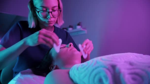 Massage session - ung blond kvinna med jade stenar i ansiktet på sin kvinnliga klient — Stockvideo