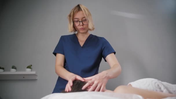 Massage session - ung blond kvinna terapeut med fingrarna i ansiktet på sin klient — Stockvideo