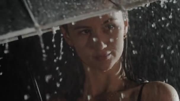 Romantik genç kadın yağmurun altında şemsiye tutuyor. — Stok video