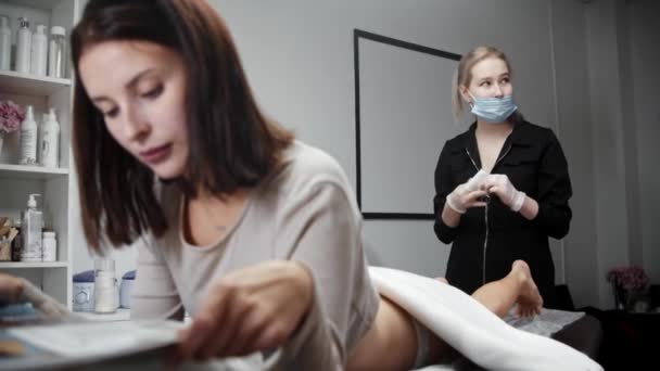 Ağda işlemi - kadın dergi okurken usta bacaklarını tükürüyor — Stok video