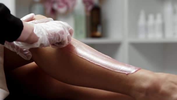 Depilación maestro rasga una tira de cera de la pierna femenina — Vídeo de stock
