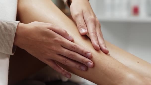 Молодая женщина держит пальцы на гладкой ноге после депиляции — стоковое видео