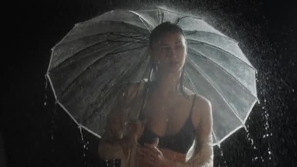 Yağmurun altında duran ve şemsiyesiyle dönen ateşli genç bir kadın. — Stok video