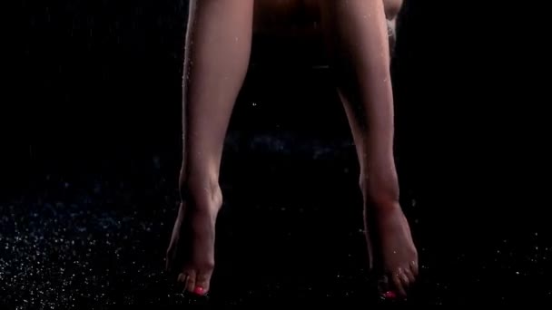 Seksi vücutlu seksi bir kadın yağmurun altında sandalyeye oturur ve bacak bacak üstüne atar. — Stok video