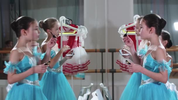 Kleine ballet meisjes staan voor een spiegel en zet make-up op — Stockvideo