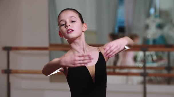 Liten flicka ballerina promenader visar balett rörelser med händerna — Stockvideo