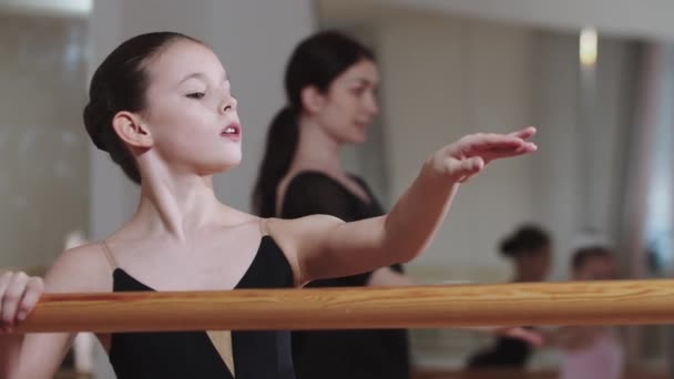 Довольно элегантный балет для девочек с группой других девушек в студии — стоковое видео