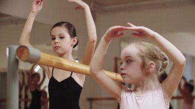 İki balerin kız sehpanın yanındaki stüdyoda çalışıyor.