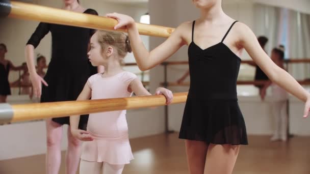 Piccola ballerina modesta che si allena nello studio vicino allo stand con la loro allenatrice — Video Stock