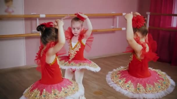Niñas en vestidos rojos bailan ballet bailan en círculo — Vídeos de Stock