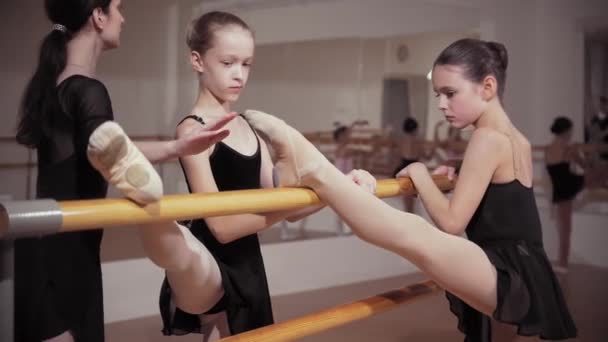 Балетная подготовка - у стенда растягиваются студенты в черной форме — стоковое видео