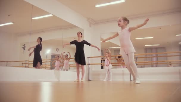 Балетная подготовка - три девчонки на балетной тренировке со своим тренером - девушки по очереди танцуют — стоковое видео