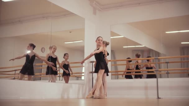 Балетная подготовка - в студии танцуют балерины в черных платьях — стоковое видео