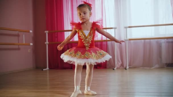 Маленькая девочка в красном платье прыгает на месте — стоковое видео