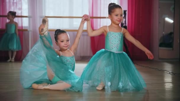 Pequenas meninas de balé em vestidos azuis mostrando um movimento de sua dança — Vídeo de Stock
