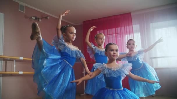 Vier kleine meisjes in blauwe jurken trainen hun dans voor de voorstelling — Stockvideo