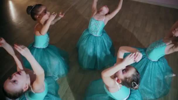 Meninas em vestidos azuis sentar em um círculo e esticar para trás — Vídeo de Stock