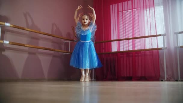 Quatro meninas bailarina em vestidos azuis andam em uma fileira e andam em torno de seus dedos da ponta — Vídeo de Stock