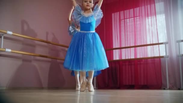 Чотири дівчата-балерини в блакитних сукнях бігають поспіль і кружляють — стокове відео