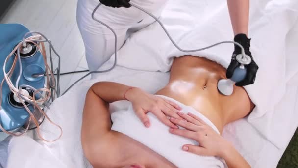 Массаж тела - женщина, лежащая на диване и получающая антицеллюлитный массаж — стоковое видео