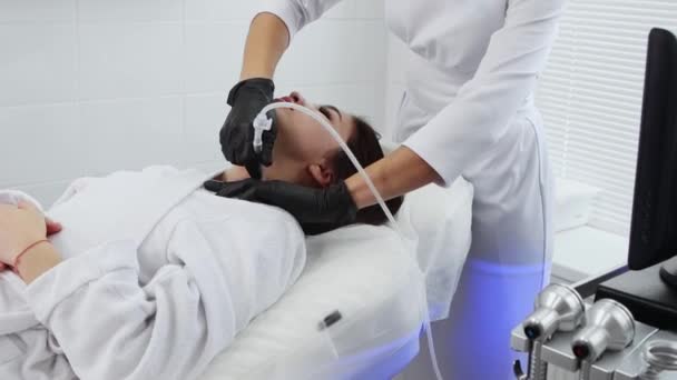 Masaż twarzy - młoda kobieta poddawana zabiegowi masażu elektrycznego na szyi — Wideo stockowe