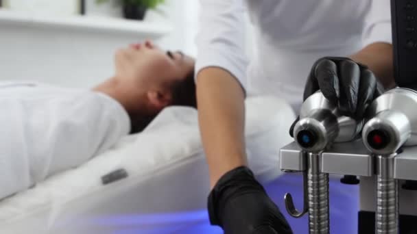 Massage du visage - thérapeute utilise la lumière ultraviolette sur un visage de femme — Video