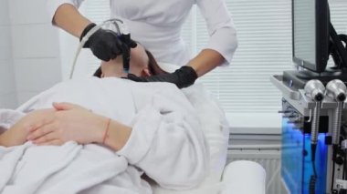 Vücut masajı - genç bir kadın boynunda elektrikli masaj yaptırıyor.