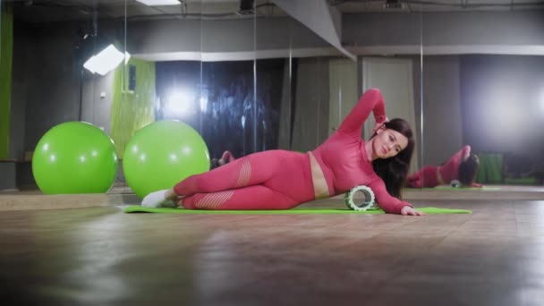 Mladá žena se opírá o lavici pod žebry a cvičí — Stock video