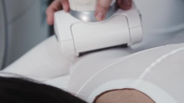 Jovem recebe massagem elétrica em seu corpo vestido com terno branco especial — Vídeo de Stock