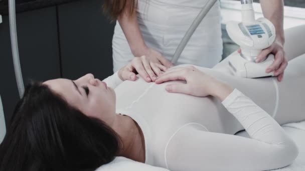 Massage GPL sur jeune femme brune vêtue d'un costume spécial blanc — Video