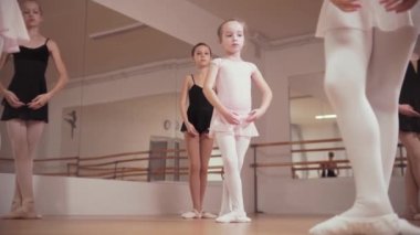 Bale eğitimi. Bir grup küçük balerin kız stüdyoda pozisyon alıyorlar.