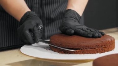 Masadaki çikolatalı keki keser.