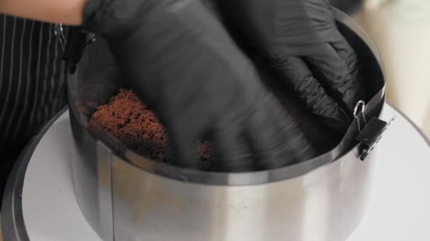 Cukiernik obniża ciasto czekoladowe gąbki do okrągłego kształtu — Wideo stockowe