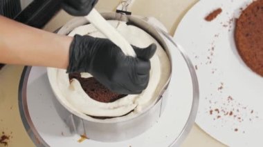 Şekerci kekin üst kısmına vanilyalı krema sıkıyor.