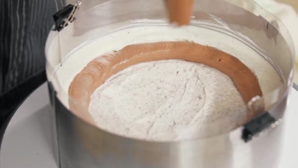 Confectioner pressar kola grädde på svamp tårta med vanilj grädde på toppen — Stockvideo