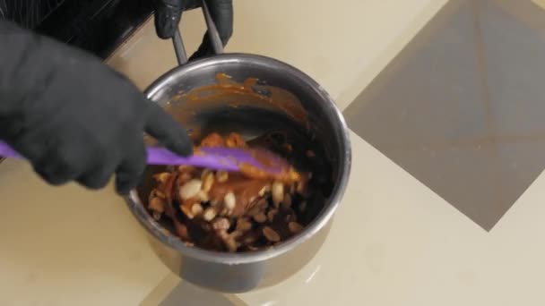 Banketbakker mengt karamel met pinda 's in een pan — Stockvideo