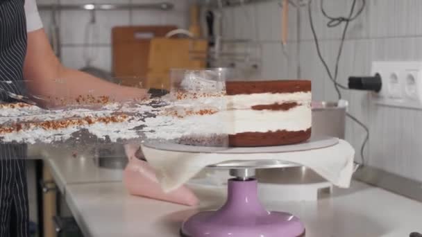 Kuchař odstraní obal z dortu a nanese na něj růžový krém. — Stock video