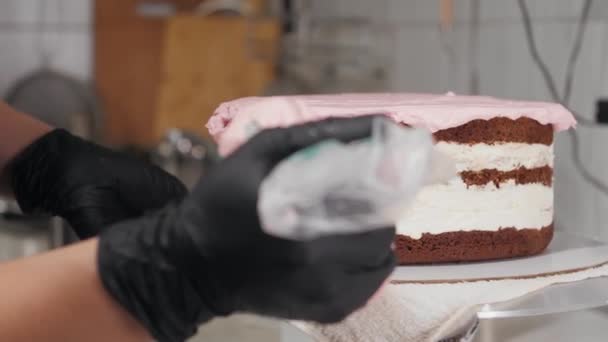 빵집의 요리사가 케이크빈 아래쪽에 핑크 크림을 바르는 모습 — 비디오