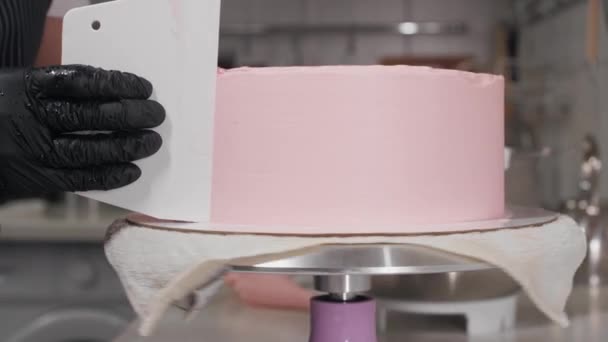 Suaviza o lado do bolo com creme rosa — Vídeo de Stock