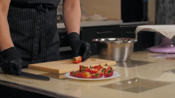 Banketbakker snijdt aardbeien in helften voor taartversiering — Stockvideo