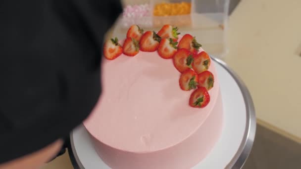 Dekorowanie różowego słodkiego ciasta kawałkami świeżych truskawek — Wideo stockowe
