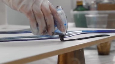 Koyu mavi epoksi reçine kullanarak bir yüzeyde tasarım çiziliyor