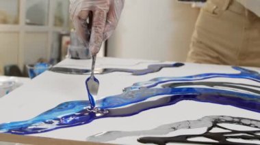 Koyu mavi epoksi reçine ve spatula kullanarak bir yüzeyde tasarım yapmak