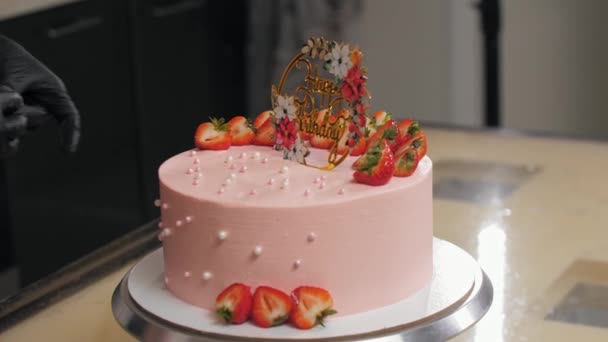 Kończy dekorowanie różowego tortu urodzinowego perłowymi jadalnymi koralikami — Wideo stockowe