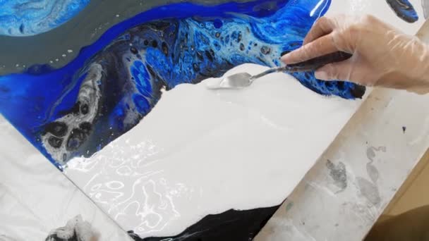 Zeichnen eines Gemäldes mit weißem Epoxidharz mit einem Spachtel — Stockvideo
