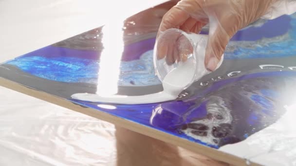 Design epóxi - derramando resina epóxi branca na superfície da pintura — Vídeo de Stock