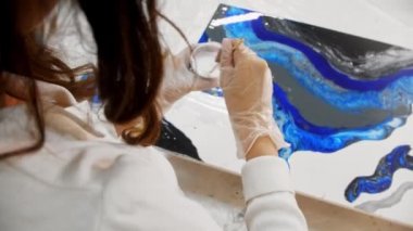 Epoksi tasarım - beyaz epoksi reçineyi karıştırıp resmin üzerine dökmek