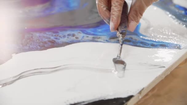 Epoxid-Design - mit einem Spachtel weißes Epoxidharz auf die Malerei schmieren — Stockvideo
